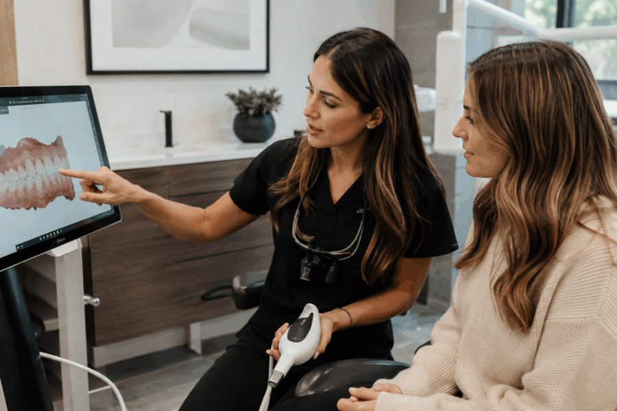 Dentist showing a patient a handheld dental instrument during a treatment consultation