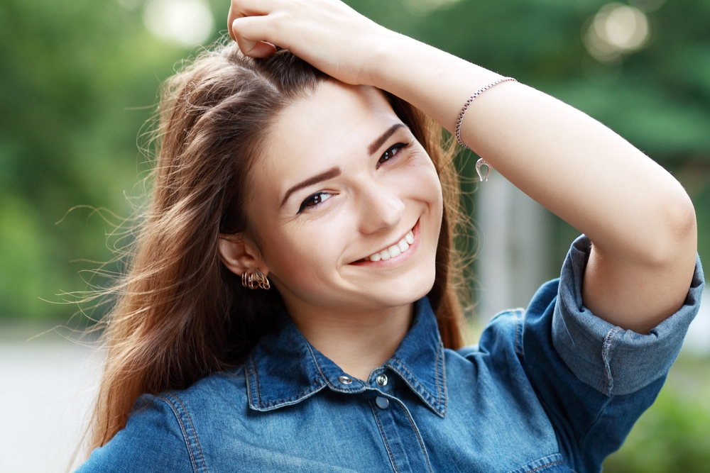 Renewed smile confidence with dental implant treatment Smiling young woman representing renewed confidence after tooth replacement in the San Marcos and San Diego community