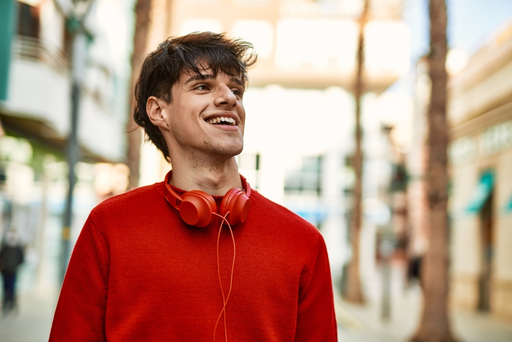 Confident smile after cosmetic dentistry Smiling young man outdoors representing confidence after a personalized smile makeover