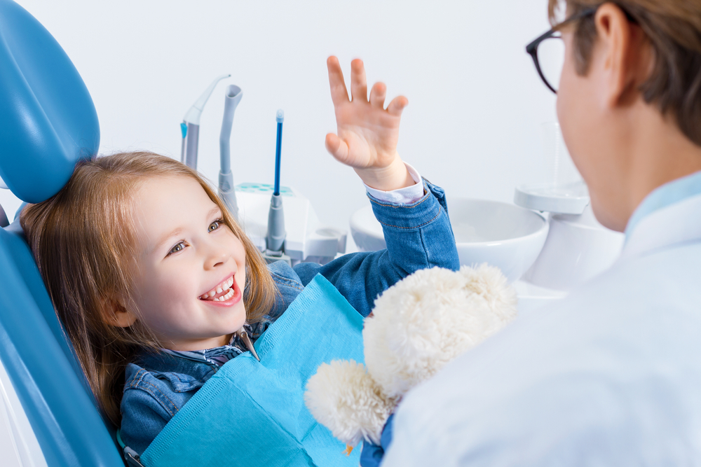Smiling child greeting a dentist during a comfortable children’s dental visit in the San Marcos and San Diego community