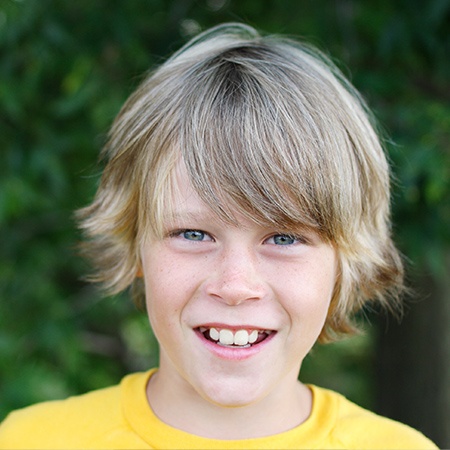 Smiling young boy outdoors representing healthy dental development in the San Marcos and San Diego community