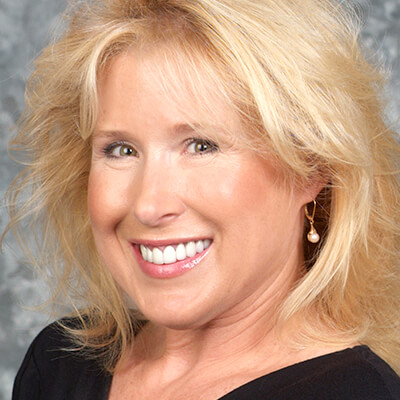 Smiling blonde woman showing bright, even teeth after cosmetic dental treatment