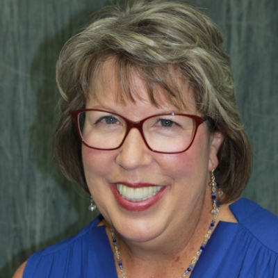 Personalized dental implant treatment for a restored smile Smiling woman with glasses showing her restored teeth after personalized implant dentistry in the San Marcos and San Diego community