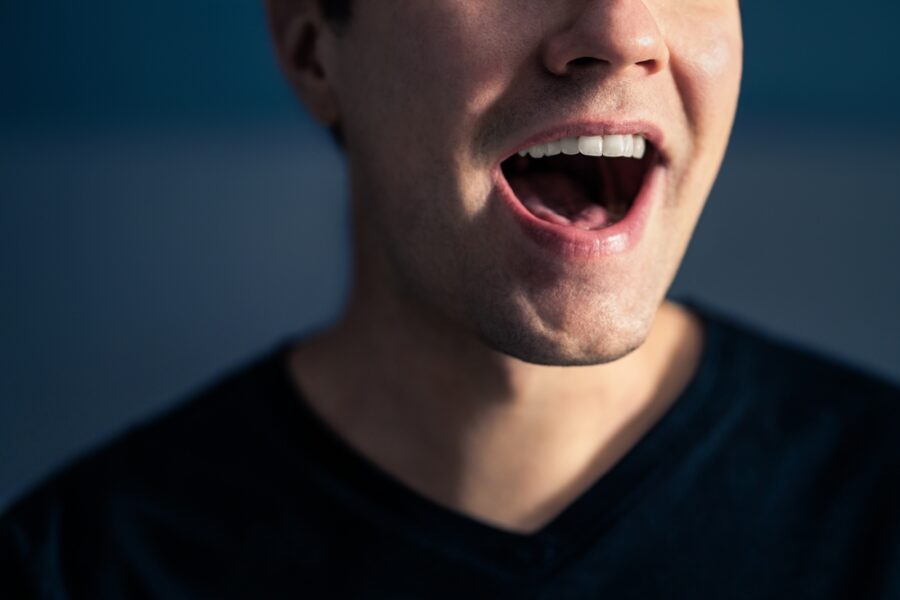 Close-up of a man's face with his mouth open wide