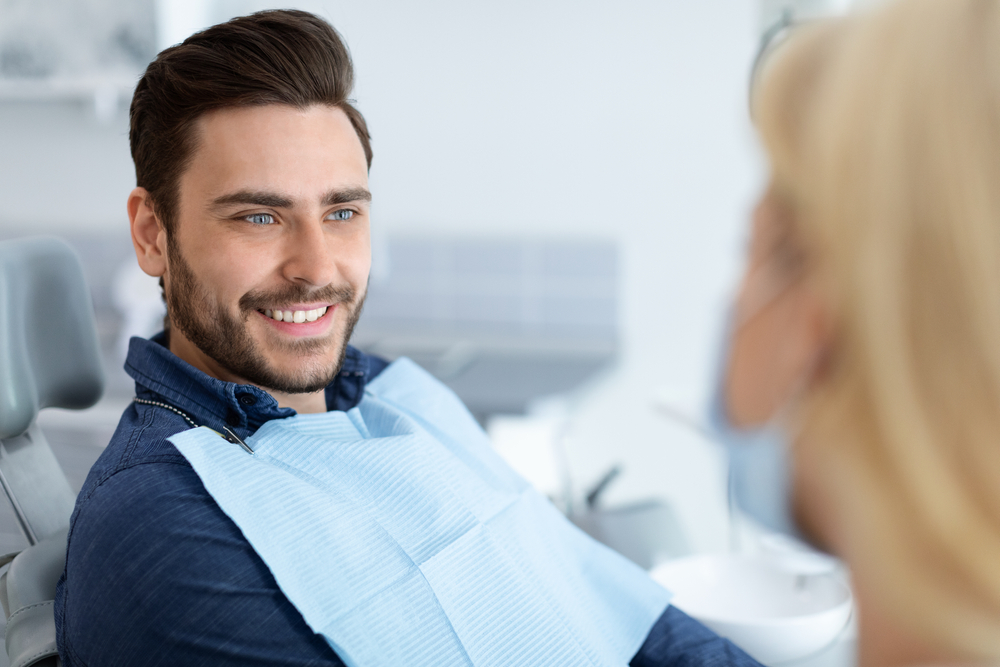 Dental implant consultation in San Marcos Smiling patient speaking with a dental professional during a dental implant consultation in San Marcos
