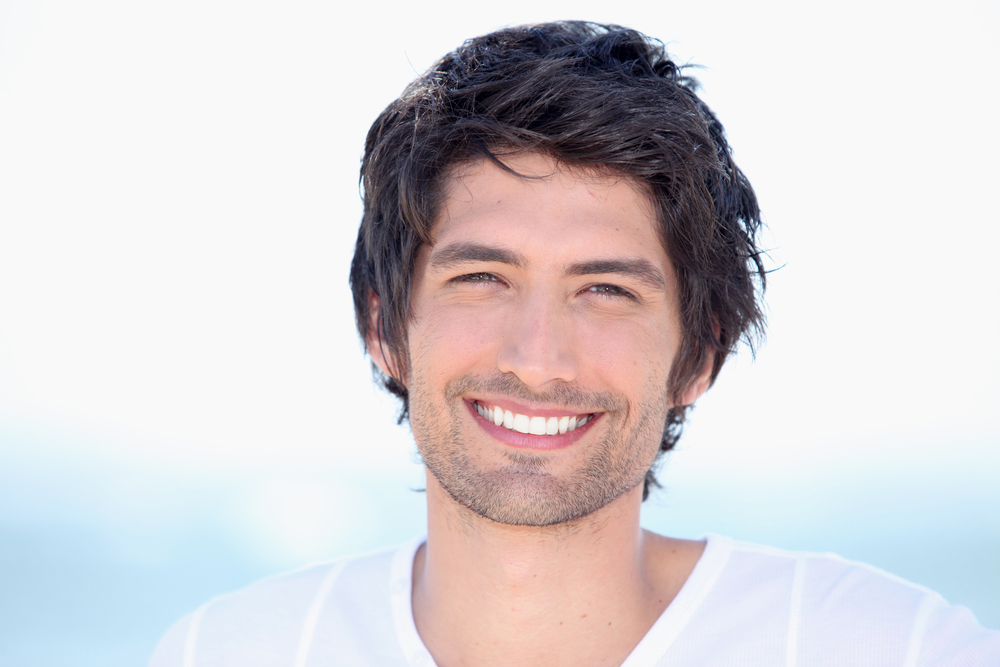 Smiling man displaying bright teeth after cosmetic dental care in the San Marcos and San Diego community