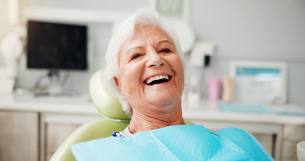 Older patient smiling in a dental chair during personalized cosmetic dental care